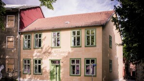 A building with a red-tiled roof, green-framed windows, and a sign indicating it is a museum. - Stylish accommodation in a monument in the heart of Halberstadt's old town (Halberstadt)
