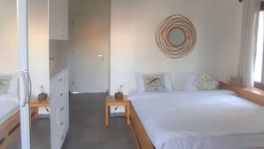 Et soveværelse med en stor seng, et klædeskab, et sengebord og en farverig måtte.