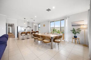 Een moderne keuken met een eethoek, een bank en een kamerplant.