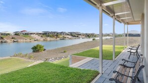 A covered outdoor area with a view of a river and houses in the background.