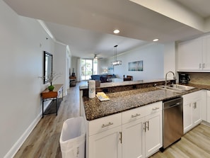 A modern kitchen with granite countertops, stainless steel appliances, and white cabinetry. - Azure #511 by Southern Vacation Rentals (Fort Walton Beach)