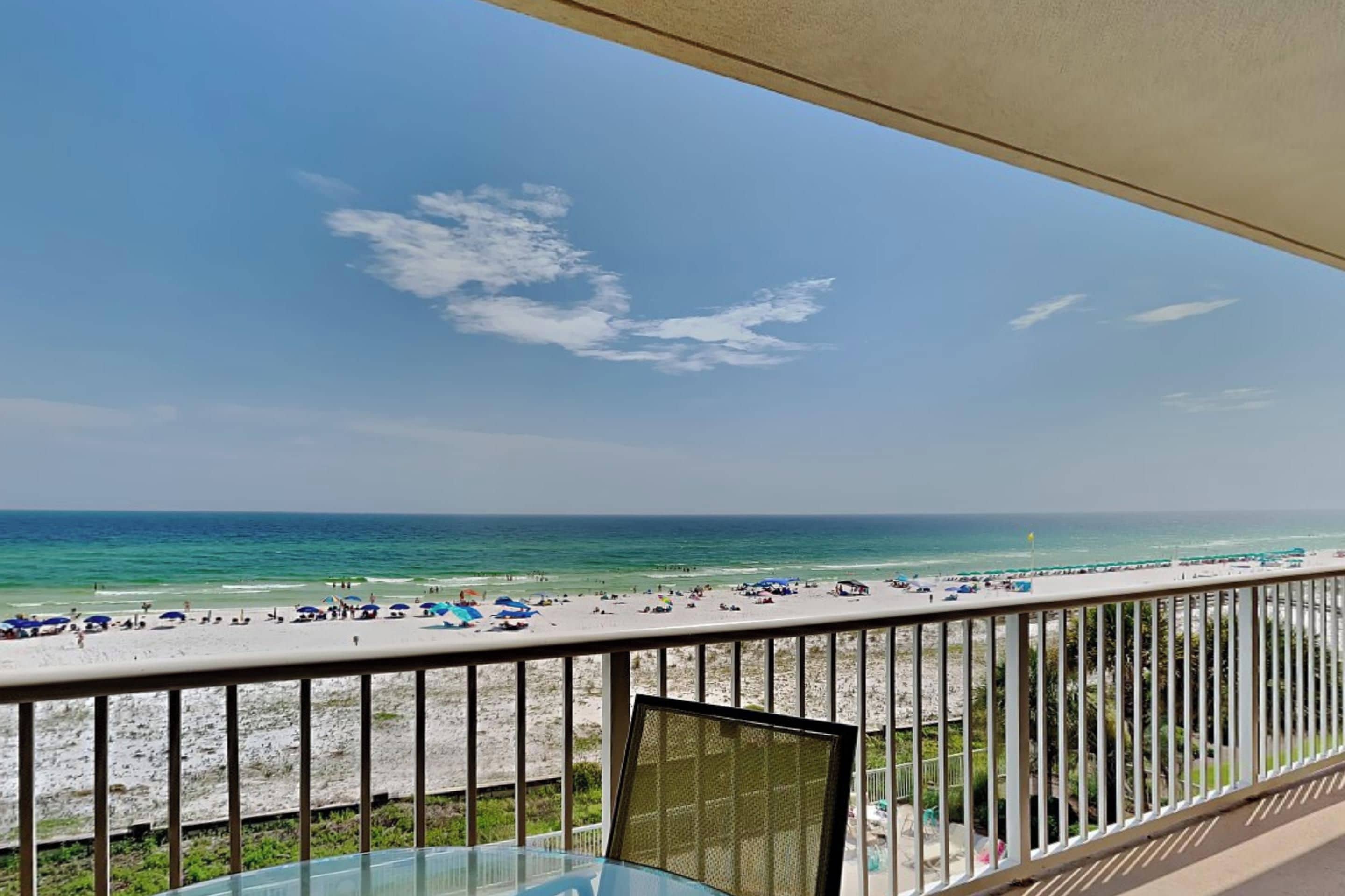 A balcony with a view of a beach and ocean.