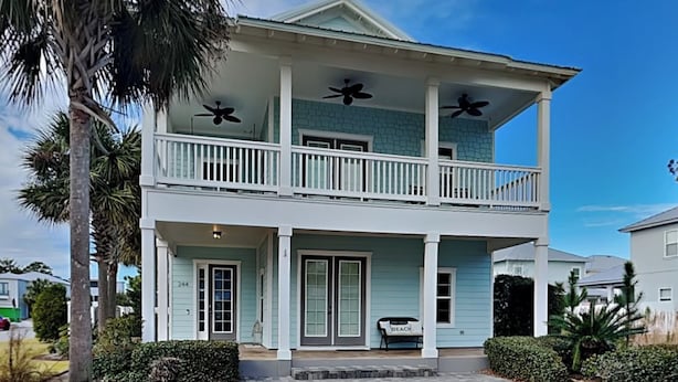 A two-story house with a balcony, a porch, and a small garden area. - Frangista Sanctuary by Southern Vacation Rentals (Miramar Beach)