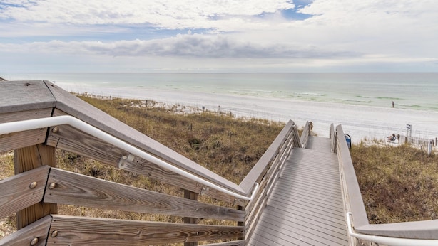 A wooden boardwalk leading to a beach with a view of the ocean and sky. - Palms North #7B by Southern Vacation Rentals (Santa Rosa Beach)