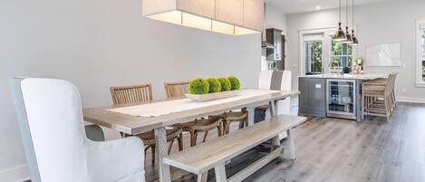 Een moderne keuken met een centraal eiland, houten vloeren en hanglampen.