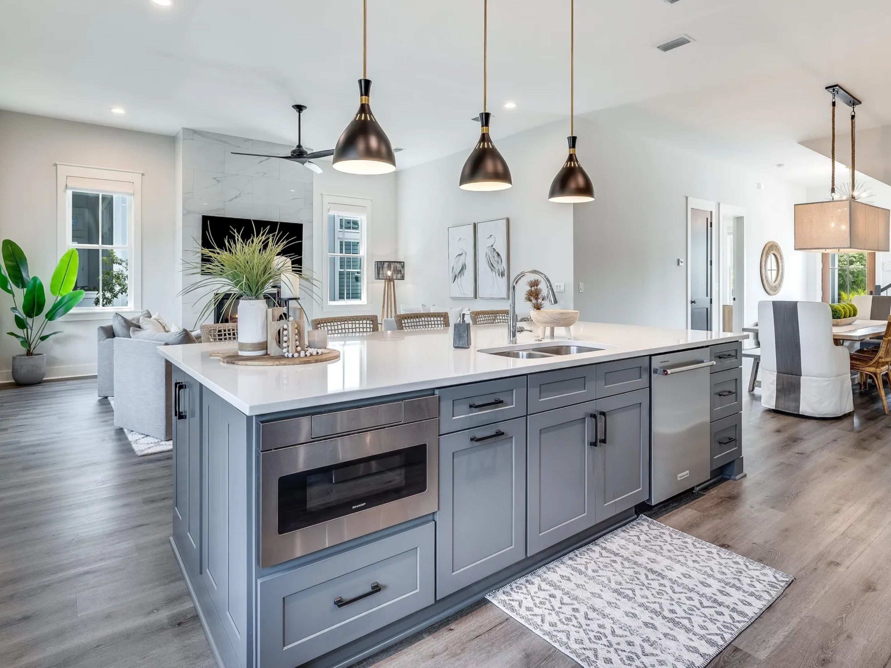 A modern kitchen with a central island, stainless steel appliances, and pendant lighting.
