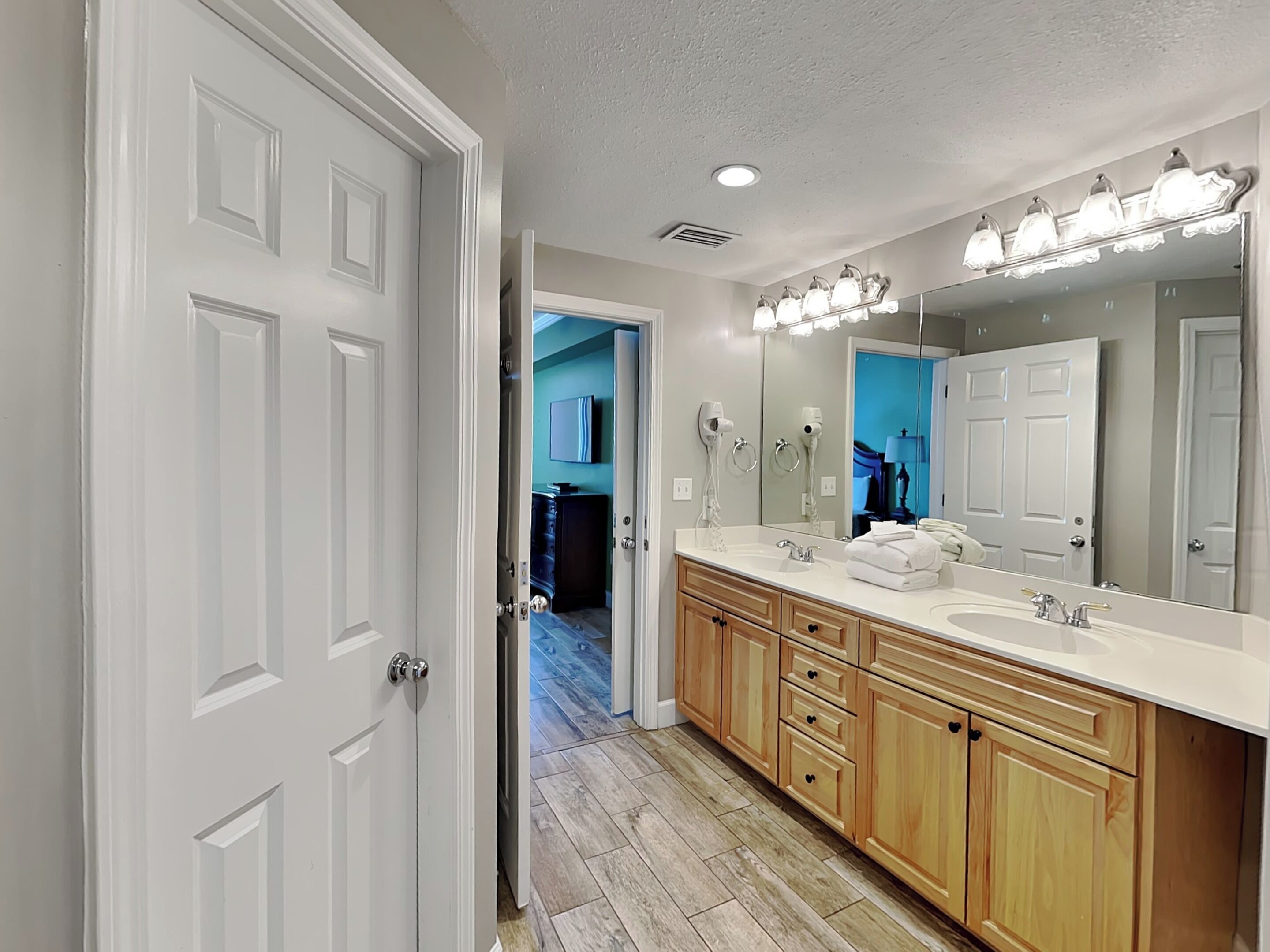 A modern bathroom with a double vanity, a large mirror, and a walk-in shower.