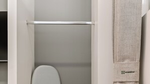 A closet with a hanging rod, a folded towel, and a small storage box. - Wenceslao By Homirent (Queretaro)