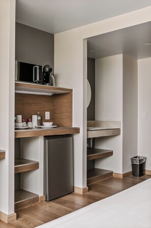 A modern kitchen with a built-in dishwasher, a microwave, and a coffee machine. - Wenceslao By Homirent (Queretaro)