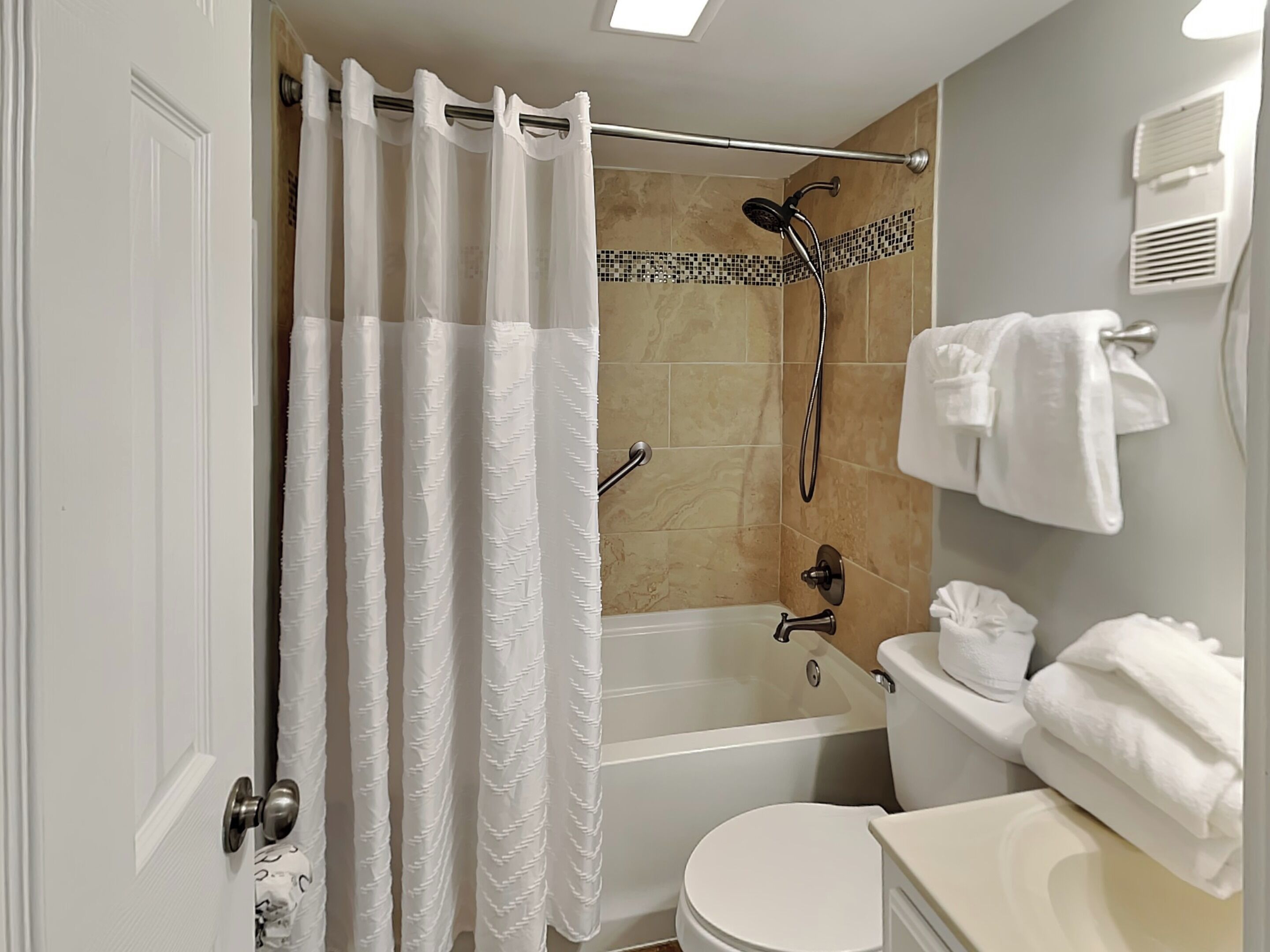A bathroom with a shower, toilet, and bathtub.
