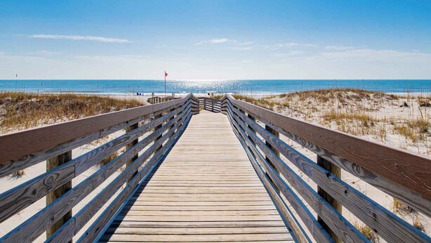 A wooden boardwalk leading to a beach with a red flag indicating no swimming. - Gulf Shores Plantation #4206 by Southern Vacation Rentals (Gulf Shores)