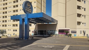 A hotel entrance with a blue sign reading "Golden Dolphin Grand Hotel". - Condominio Golden Dolphin Resort via Roberto Imoveis (Caldas Novas)