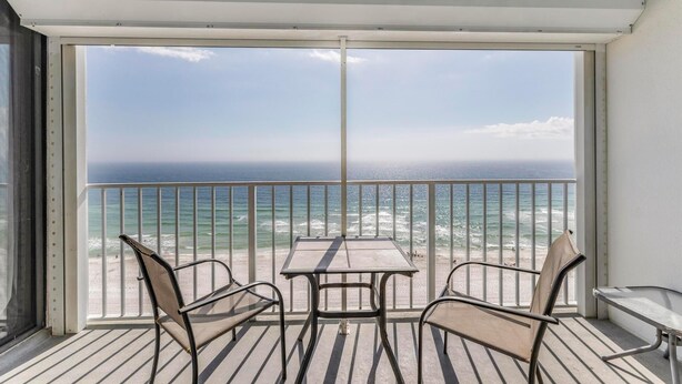 A balcony with a table and chairs, overlooking a beach and ocean. - Summerchase 1103 (Orange Beach)