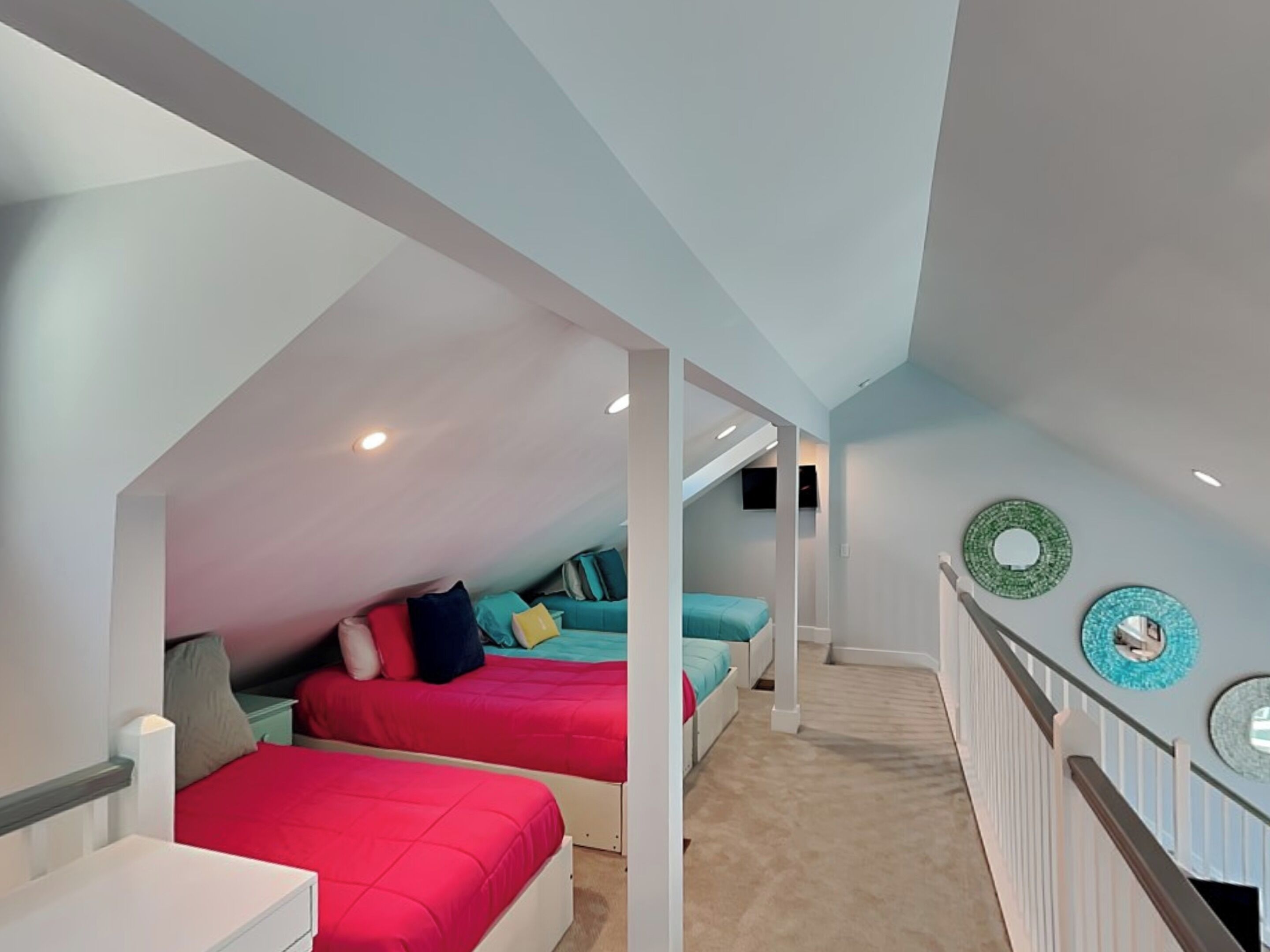 Un dormitorio con dos camas, un aparador blanco y una escalera que conduce a un nivel superior.