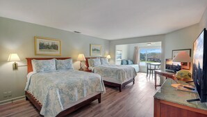 Une chambre d’hôtel avec deux lits, une table à manger et un téléviseur.
