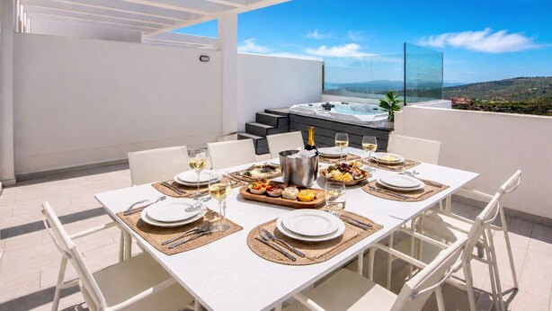 A rooftop dining area with a table set for four, a hot tub, and a scenic view. - GOLDEN VIEW 2318 (Manilva)