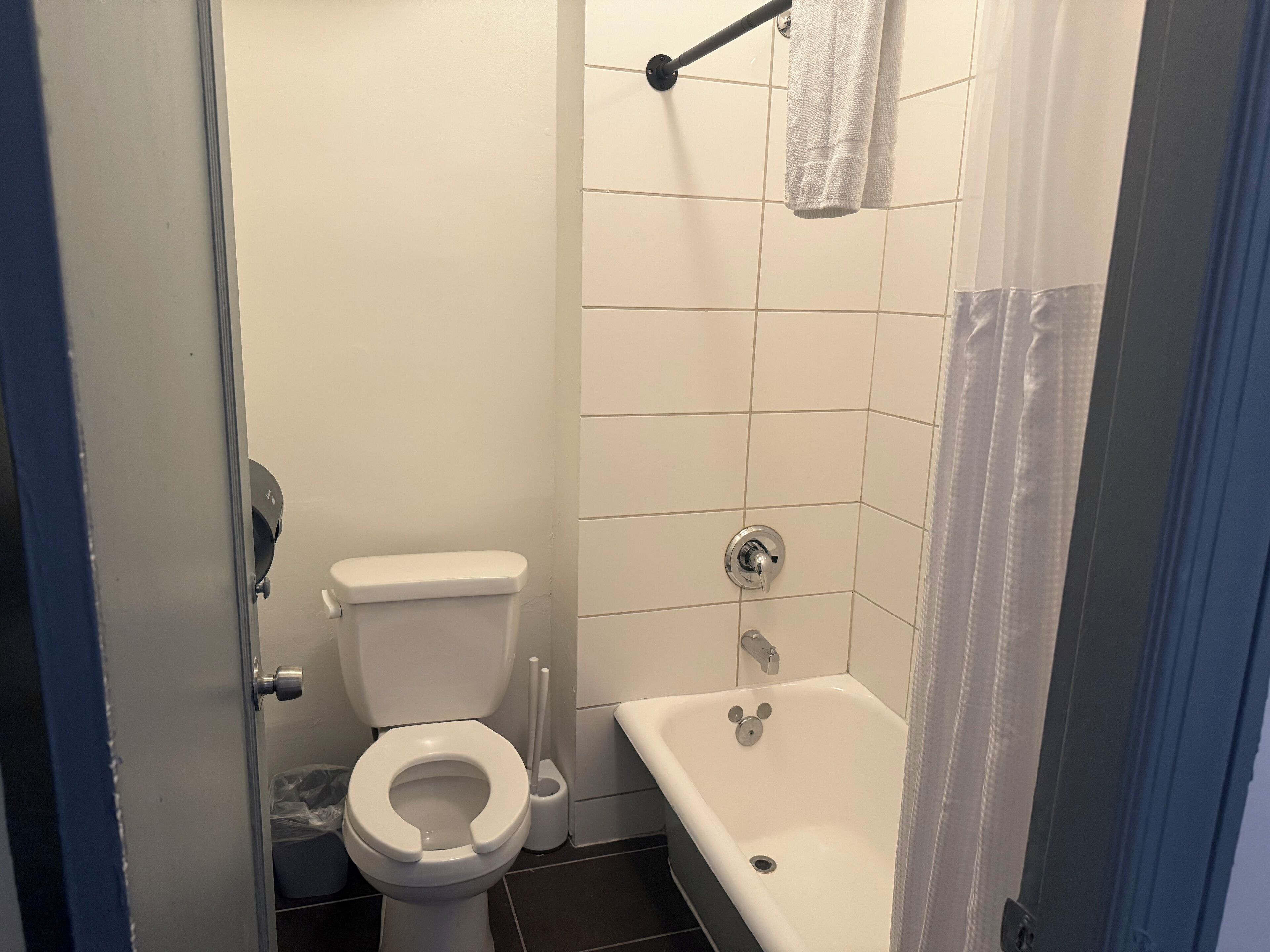 A small, clean bathroom with a toilet, a shower, and a bathtub.