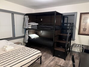 A bunk bed room with a desk and chair, a window with blinds, and a framed picture on the wall. - Hostel Fish Seattle (Seattle)