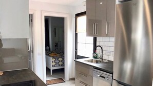 Una cocina moderna con electrodomésticos de acero inoxidable, lavavajillas y un refrigerador grande.