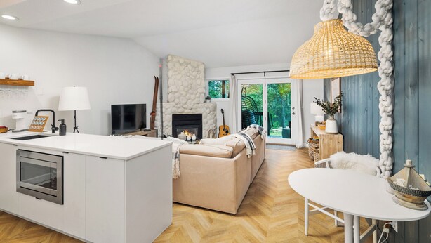 A modern kitchen with a central island, a dining area with a white table, and a cozy seating area with a sofa. - Hank's Lake & Links: The Legend (Biwabik)