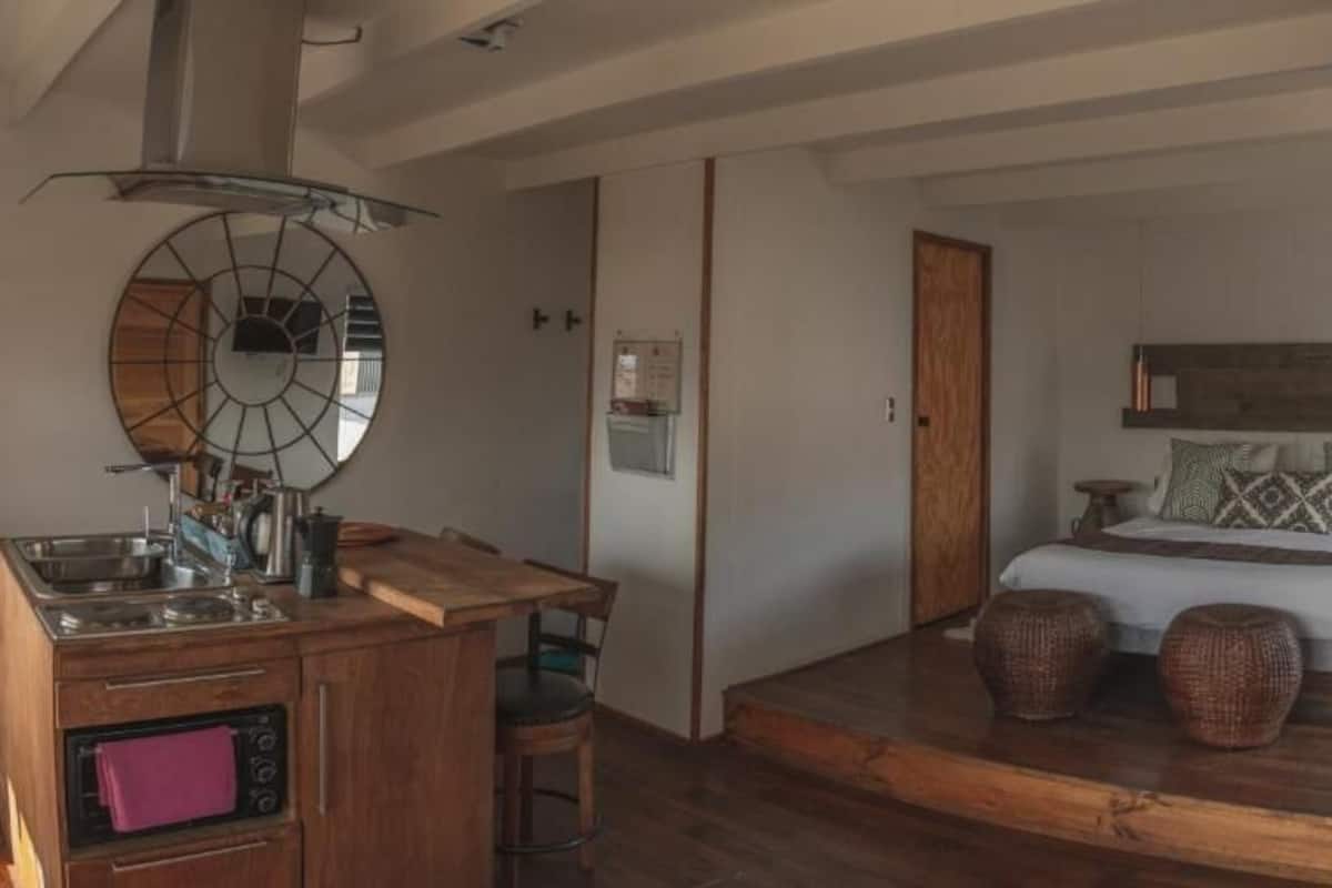 Une chambre à coucher avec un lit, une tête de lit en bois, une table de chevet et une commode.