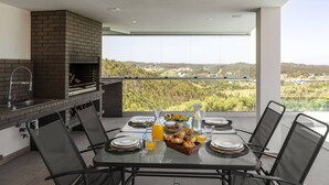 Un comedor con una mesa dispuesta para cuatro personas, chimenea de ladrillo y vistas panorámicas.