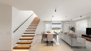 Una sala de estar moderna con una escalera, un comedor y un sofá.