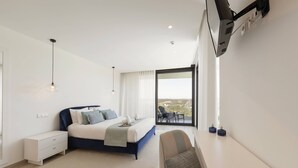 Un dormitorio moderno con cama, mesita de noche y vistas al exterior.