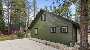 A green house with a sloped roof, two windows, and a number '39414' on the side.
