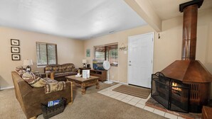 A living room with a fireplace, a sofa, a coffee table, and a television.