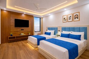 A hotel room with two beds, a TV mounted on the wall, and a ceiling fan. - Hotel Urban Royale Near IGI Airport  (New Delhi)