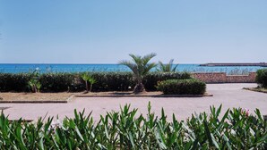 A paved walkway with palm trees and a view of the sea. - Cozy waterfront apartment, 10 min.ValledeiTempli-Casa al Mare Circe (San Leone)
