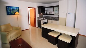 A compact kitchen with a dining area, a sofa, and a lamp. - Apart Riviera Tower Suites (Villa Carlos Paz)