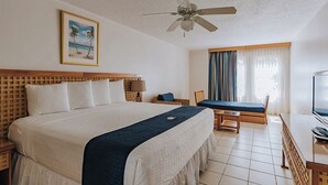 A hotel room with a large bed, a ceiling fan, a television, and a window with curtains. - Charming 2Br, 2 bath Resort Condo,AC,pools,hot tubs,1M to main strip/beach,Aruba (Aruba)