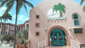 A building with a palm tree logo and the text "Caribbean Palm Village Resort". - Charming 2Br, 2 bath Resort Condo,AC,pools,hot tubs,1M to main strip/beach,Aruba (Aruba)
