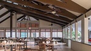 A spacious indoor dining area with multiple tables and chairs, large windows, and ceiling fans. - Charming 2Br, 2 bath Resort Condo,AC,pools,hot tubs,1M to main strip/beach,Aruba (Aruba)