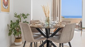A dining area with a round table, six chairs, and a view of the ocean. - Apartment in Andalucia del Mar for 4 persons | ADM 14 617 (Puerto Banús - Marbella)