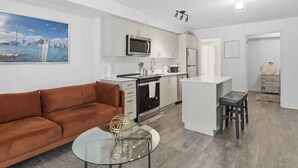 Um apartamento moderno com cozinha compacta, sala de jantar e sala de estar.