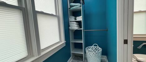 Un baño con pared azul, puerta blanca e inodoro blanco.