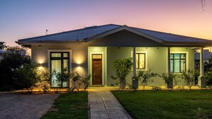 A modern house with a paved driveway, a front door, and a covered porch area. - Stunning 3 Bedroom House Near Harare Airport -2297 (Harare)