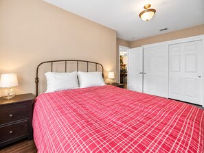 Une chambre d’hôtel avec un lit, des tables de chevet, une lampe et une armoire.