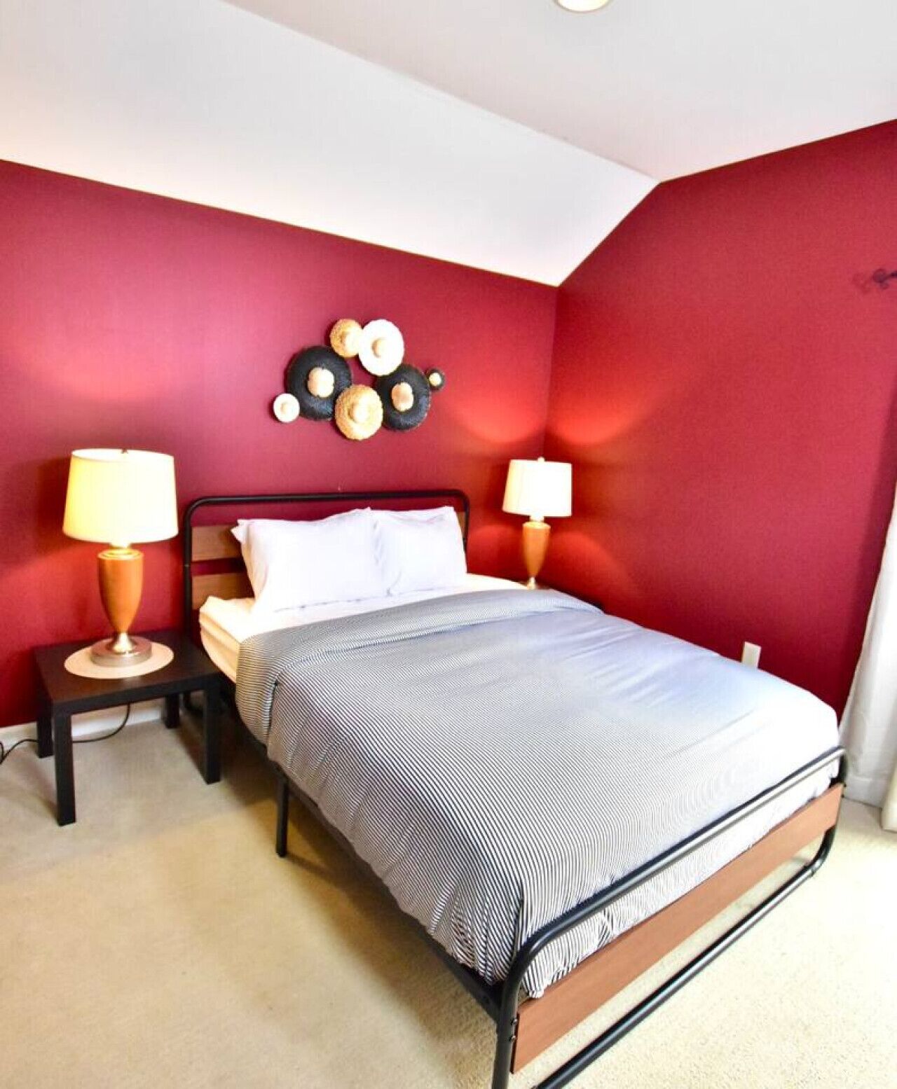Une chambre à coucher avec un lit, deux tables de chevet et des lampes.