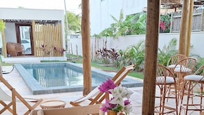 An outdoor dining area with wicker placemats, white tableware, and a vase with flowers. - Pousada Oasis dos Ventos (Touros)