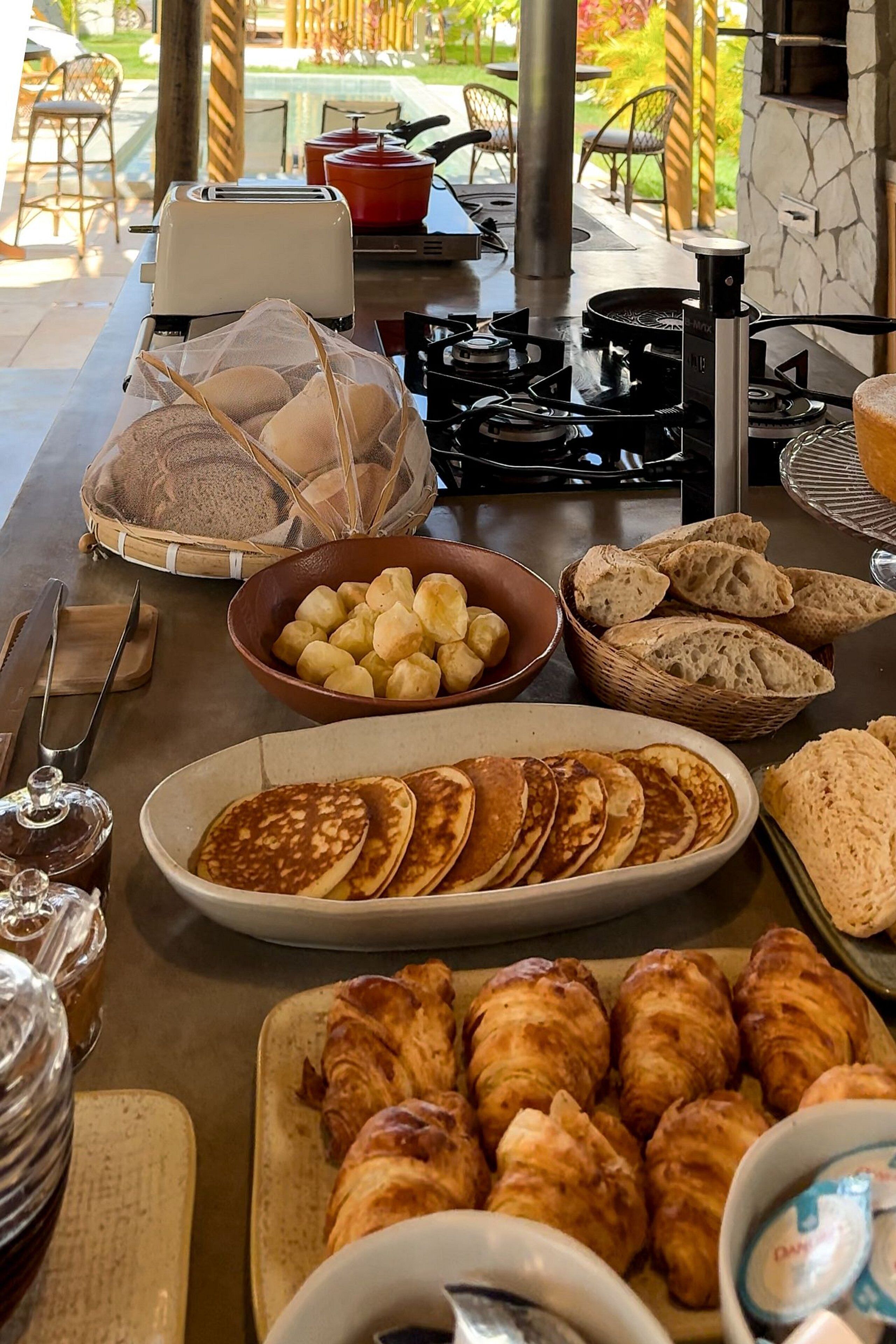 Un bufé de desayuno con pan, bollería y una tostadora.