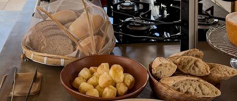 Un bufé de desayuno con pan, bollería y una tostadora.