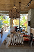 Una mesa de buffet con diversos alimentos y utensilios, un lámpara colgante de tejido, y vista al exterior.