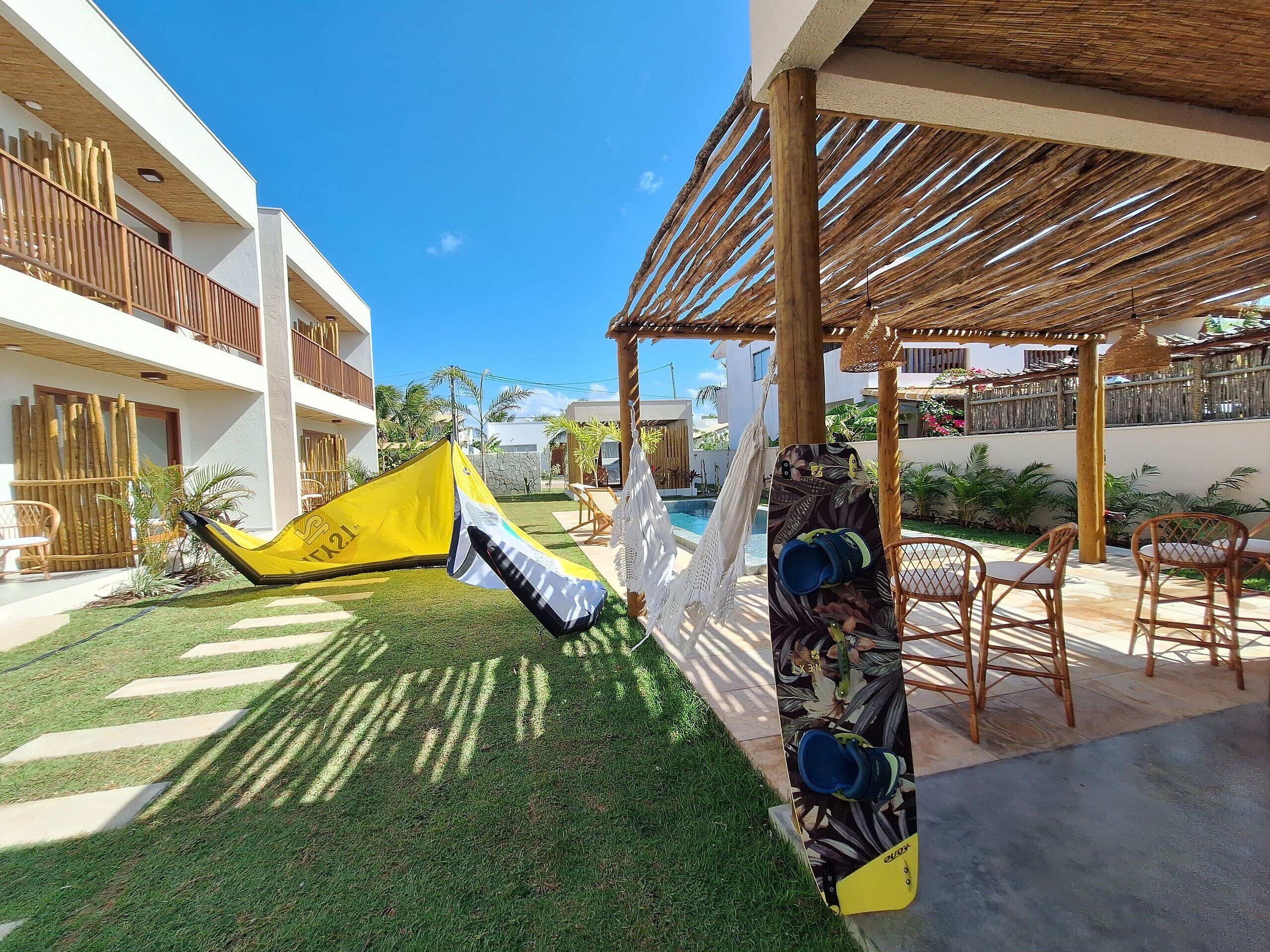 Um pátio com rede, piscina e área de estar externa.