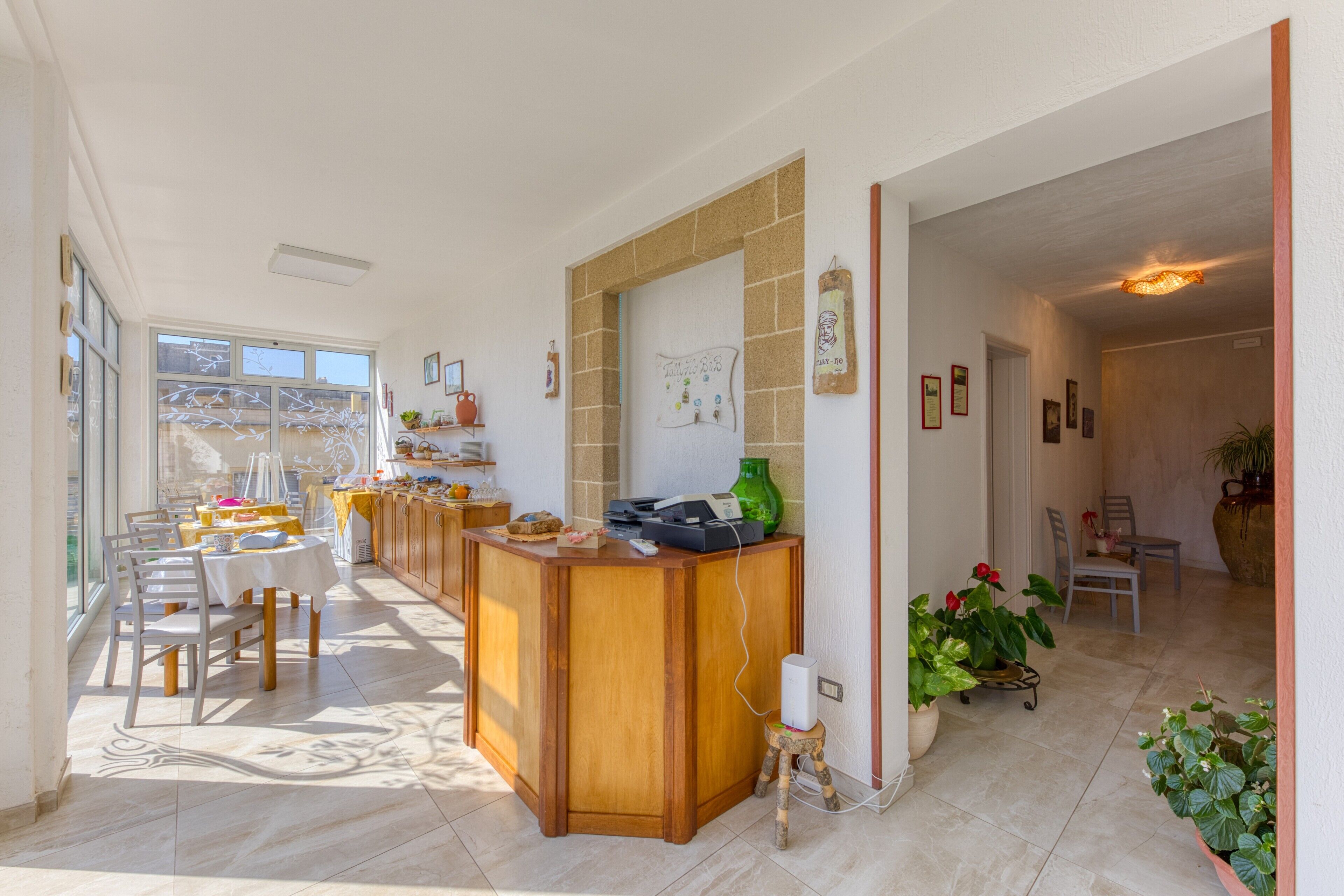 A spacious kitchen with a wooden island, a dining area with chairs, and a view through large windows.