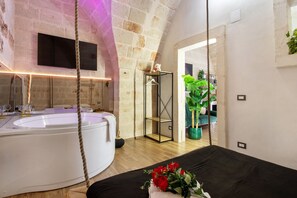 A spa room with a bathtub, a hanging chair, and a plant. - Apartment 'Angelsuite' with Wi-Fi and Air Conditioning (Br)