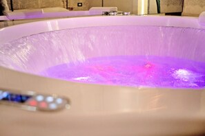 Une baignoire dotée d’un panneau de commande et d’un éclairage violet.